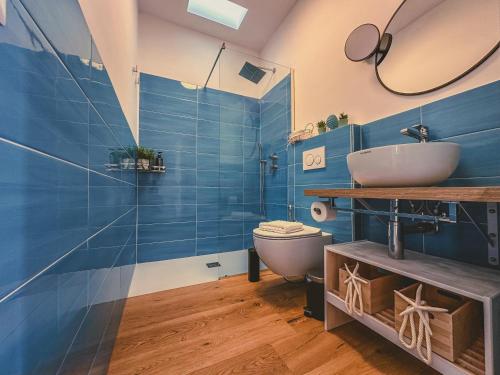 a blue bathroom with a sink and a toilet at La La Land in Letojanni