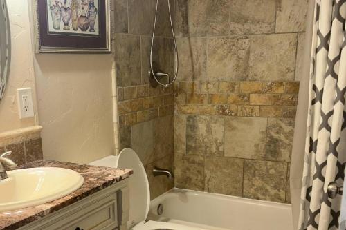 a bathroom with a sink and a tub and a toilet at Glen Eagles Cozy Queen in Colorado Springs