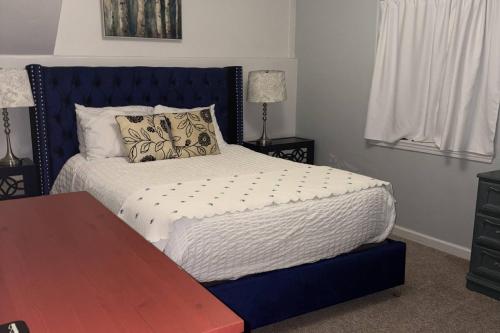 a bedroom with a bed with a blue head board at Glen Eagles Cozy Queen in Colorado Springs