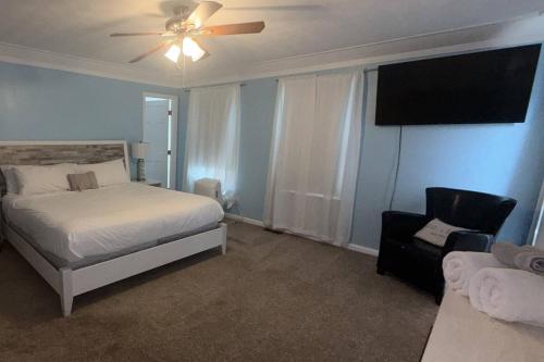 a bedroom with a bed and a fan and a chair at Glen Eagle Kingfisher Suite in Colorado Springs