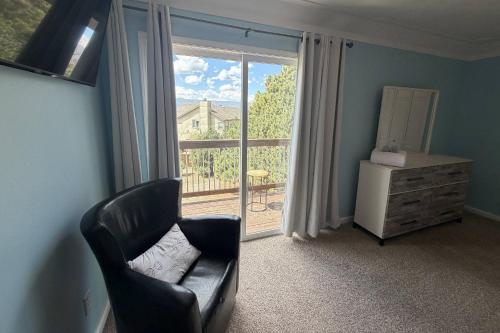 a living room with a chair and a window at Glen Eagle Kingfisher Suite in Colorado Springs