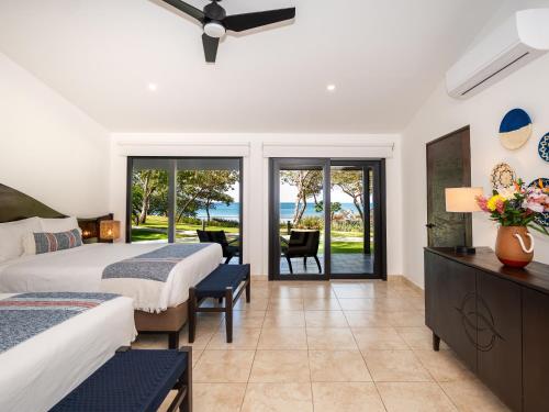 a bedroom with two beds and a view of the ocean at Reunion Wellness Resort & Retreats in Playa Danta