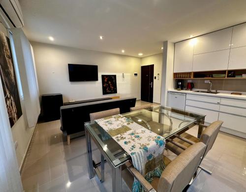 a living room with a glass table and a kitchen at House51 "ubicado a solo 3 cuadras de la playa en pleno centro de Rada Tilly" in Rada Tilly