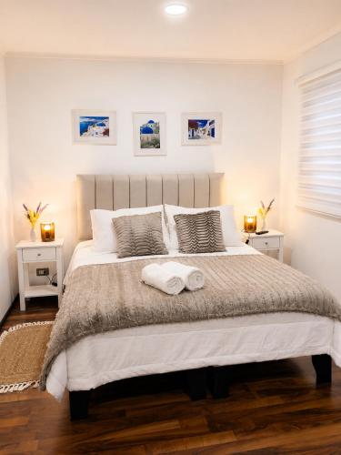 a bedroom with a large bed with two towels on it at Alojamiento en Paine cerca Monticello in Hijuela Larga