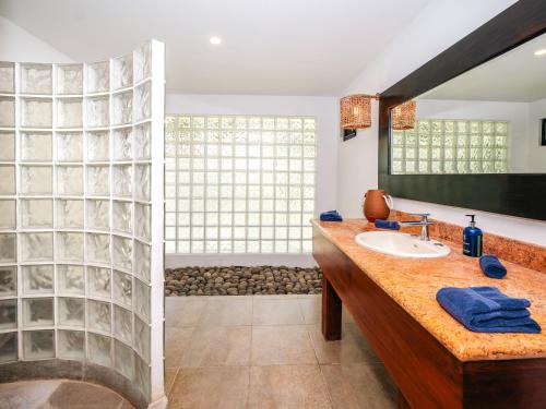 a bathroom with a sink and a large window at Reunion Wellness Resort & Retreats in Playa Danta