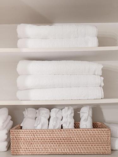 a bunch of towels are stacked on a shelf at Central Family Flat Volos in Volos