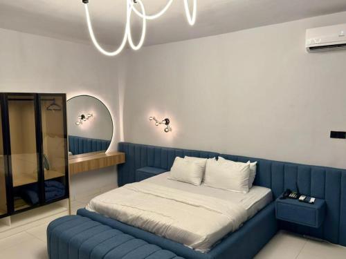 a bedroom with a blue bed and a mirror at Pc Luxury 1 bedroom with pool in Lagos