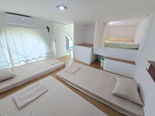 a room with two beds and a window at Posada Bugambilias in Catemaco