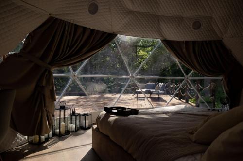 a bedroom with a bed in front of a large window at Sandomierskie Szepty Lasu - Glamping Sandomierz in Gałkowice