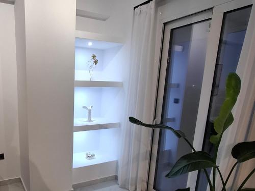 a room with shelves with a plant and a window at Hanna's Villagio in Korinthos