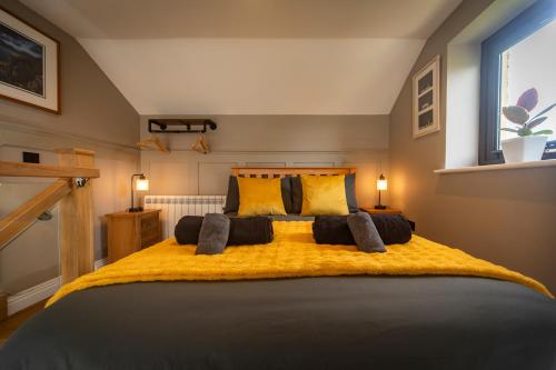 a bedroom with a large bed with a yellow blanket at Am Bothan - Pied-à-terre in Portree