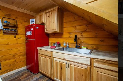 a kitchen with a red refrigerator and a sink at The Rustic Charm in Sevierville