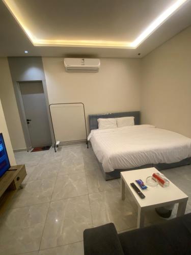 a bedroom with a bed and a table and a tv at Condo in Alramal near to the airport in Riyadh