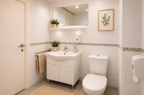 a white bathroom with a toilet and a sink at All inclusive Villa Four Pearls in Trogir