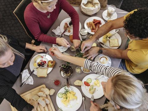 a group of people sitting around a table eating food at ibis budget Berlin Hoppegarten in Hoppegarten