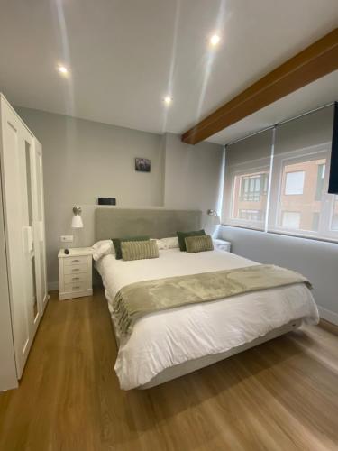a bedroom with a large bed and a wooden floor at Alojamiento con encanto in Santoña