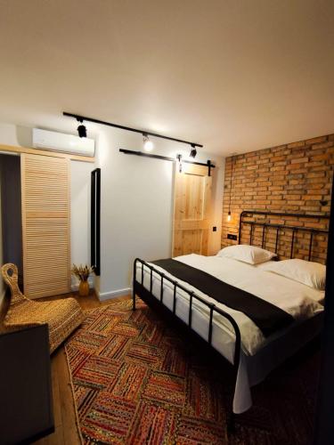 a bedroom with a large bed and a brick wall at Casa FaRa in Vama Veche