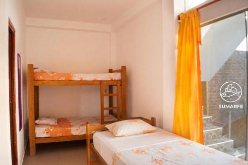 two bunk beds in a room with a window at Sumarfe in Máncora