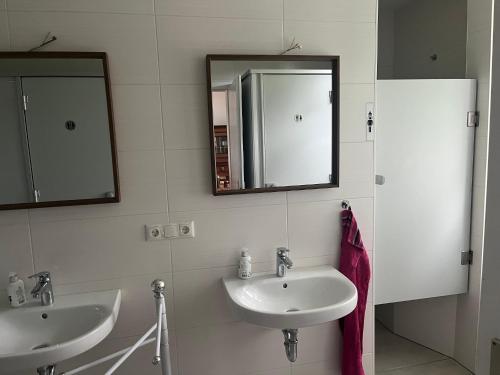 a bathroom with two sinks and two mirrors at SAAL am Pfarrhaus in Penzlin