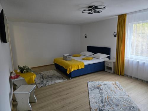 a bedroom with a bed with a yellow blanket at Casa Dani&Moni in Moieciu de Sus