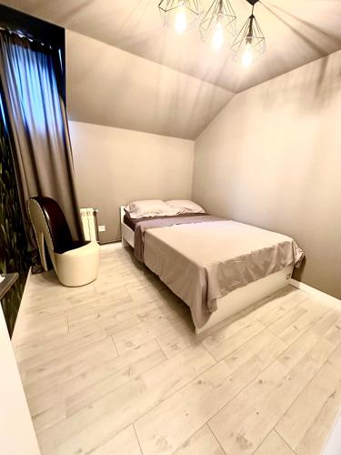 a bedroom with a bed and a chair in it at YAMM Pool House in Mali Požarevac