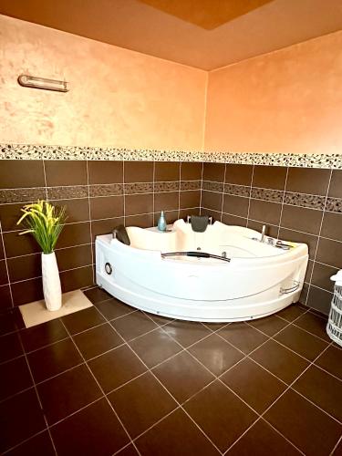 a bath tub in a bathroom with a tiled floor at YAMM Pool House in Mali Požarevac