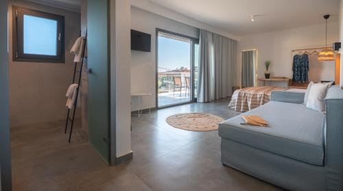 ein Zimmer mit einem Bett und einer Couch und ein Schlafzimmer in der Unterkunft Delight Suites in Limenaria