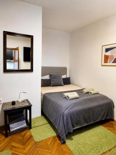 a bedroom with a bed and a mirror on the wall at Studio apartman Hinko in Đakovo