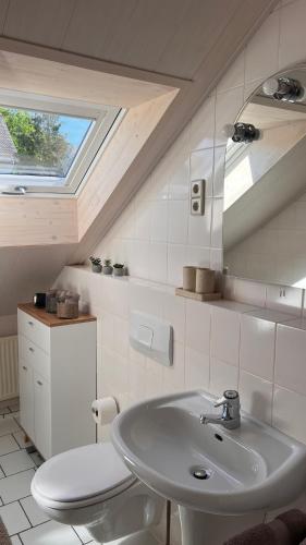 a bathroom with a sink and a toilet and a window at Haus Bergblick in Olsberg