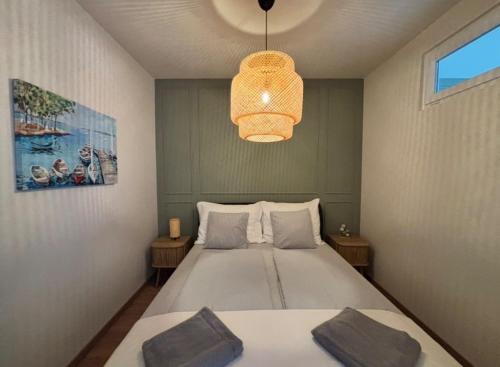 a bedroom with a bed and a pendant light at Andrea Apartman in Alsóörs