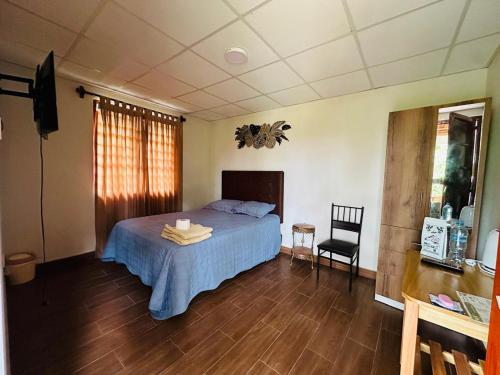 a bedroom with a bed and a table and a chair at Cabaña Moyobamba in Moyobamba