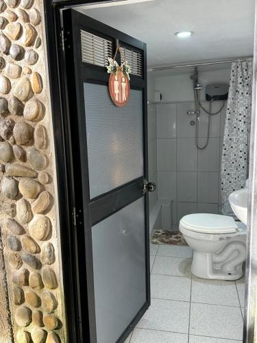 a bathroom with a toilet and a glass door at Cabaña Moyobamba in Moyobamba