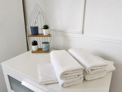 a white bathroom with white towels on a shelf at Casa da Aida - Fuzeta in Fuzeta