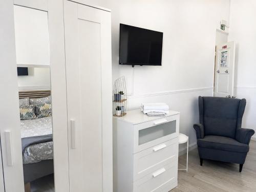 a room with a tv and a chair and a bed at Casa da Aida - Fuzeta in Fuzeta