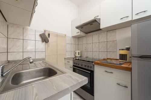 a kitchen with a sink and a stove at Apartments Ivan in Vir