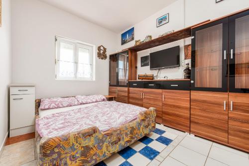 a bedroom with a bed and a flat screen tv at Apartments Ivan in Vir