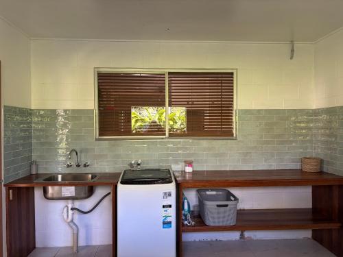 a kitchen with a sink and a refrigerator at Egrets Rest in Daintree