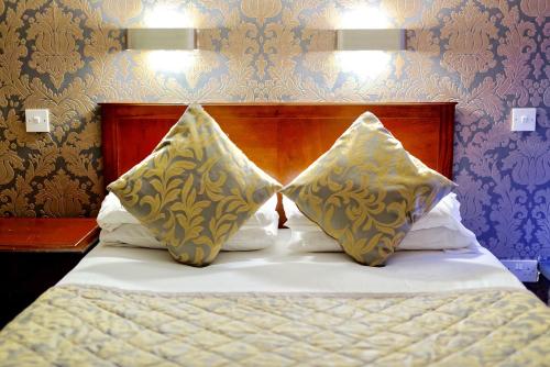 a bedroom with a bed with two pillows on it at Grainger Hotel in Newcastle upon Tyne