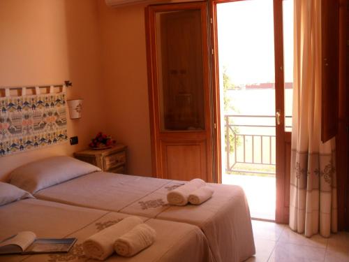 a bedroom with a bed with towels on it at Hotel Plammas in Santa Maria Navarrese