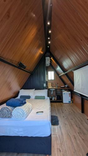 a bedroom with a large bed in a wooden ceiling at Chalé Suiço Diniz e Ferreira in Contagem