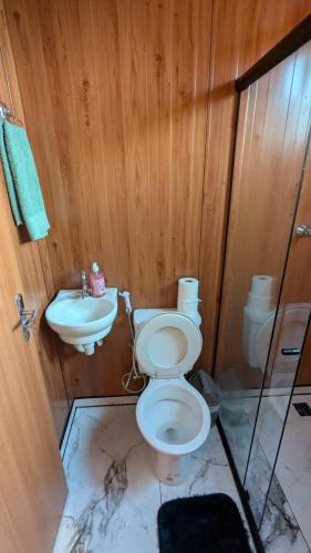 a bathroom with a toilet and a sink at Chalé Suiço Diniz e Ferreira in Contagem