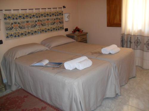 a bedroom with two beds with towels on them at Hotel Plammas in Santa Maria Navarrese