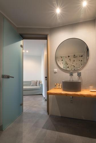 ein Badezimmer mit Waschbecken und Spiegel in der Unterkunft Delight Suites in Limenaria