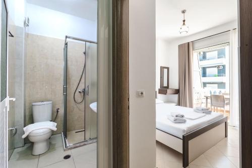 a bathroom with a toilet and a shower and a sink at Parid Apartments in Sarandë