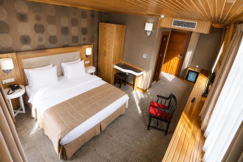 a hotel room with a large bed and a desk at Sputnik Hotel Batumi in Batumi