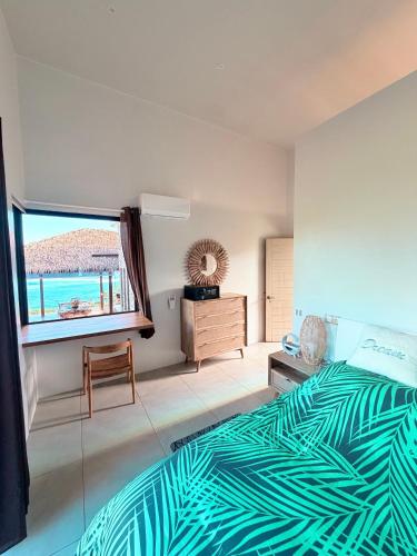 a bedroom with a bed and a large window at Villa Maeva Tahiti in Vaihi