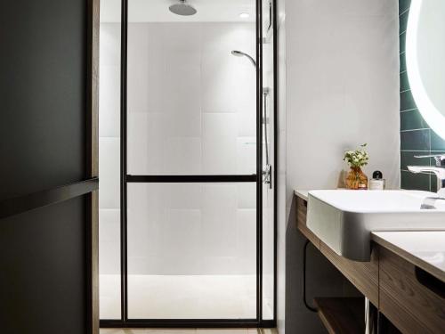 a bathroom with a shower and a sink at Novotel Sydney Darling Square in Sydney