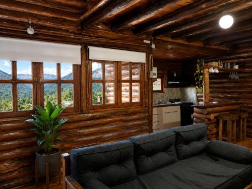 a living room with a couch and some windows at Cabañas San Michele in La Cumbrecita