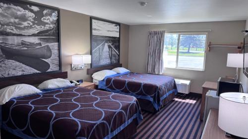 a hotel room with two beds and a window at Northwoods Inn and Suites in Ely