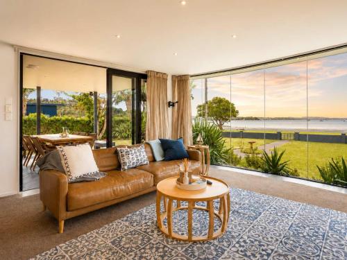 ein Wohnzimmer mit Sofa und Tisch in der Unterkunft Blackpool Bayside - Stay Waiheke in Oneroa